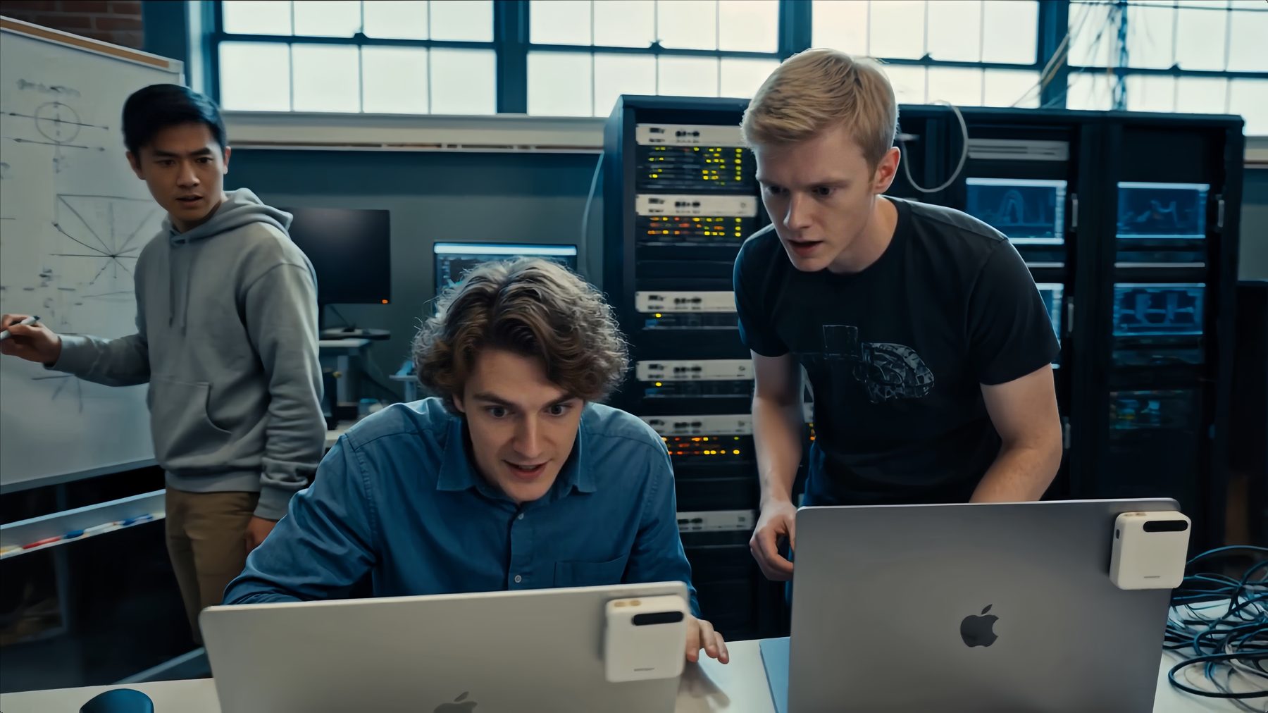 Three students around laptops in a server room, the A2 Pro on one of the lids